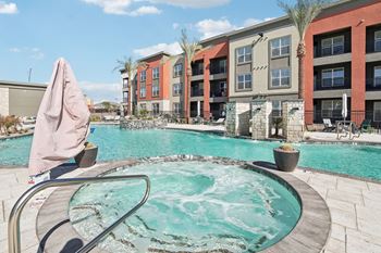 our apartments have a large swimming pool with an umbrella at The Maddox Luxury Apartment Homes, Buckeye, AZ, 85326
